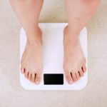 Burn fat not muscle-feet standing on white bathroom scale