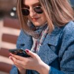 woman sitting on bench looking at phone-How To Use Mini-Fasts As Part Of Your Fasting Plan